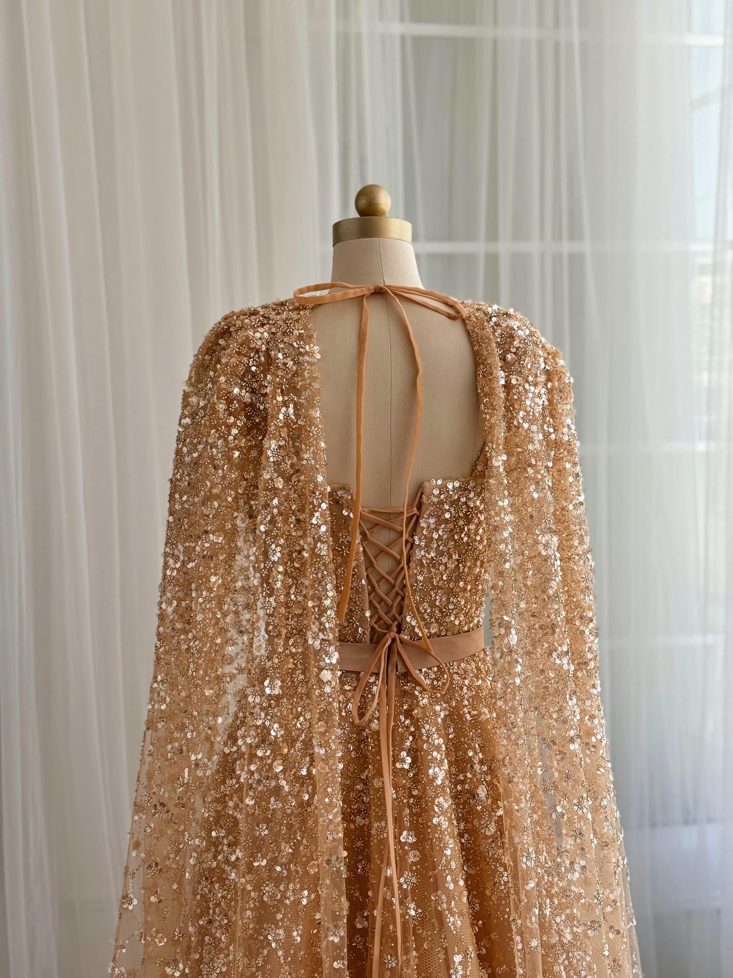 Beige A-Line gown with cape, no sleeves and sequins