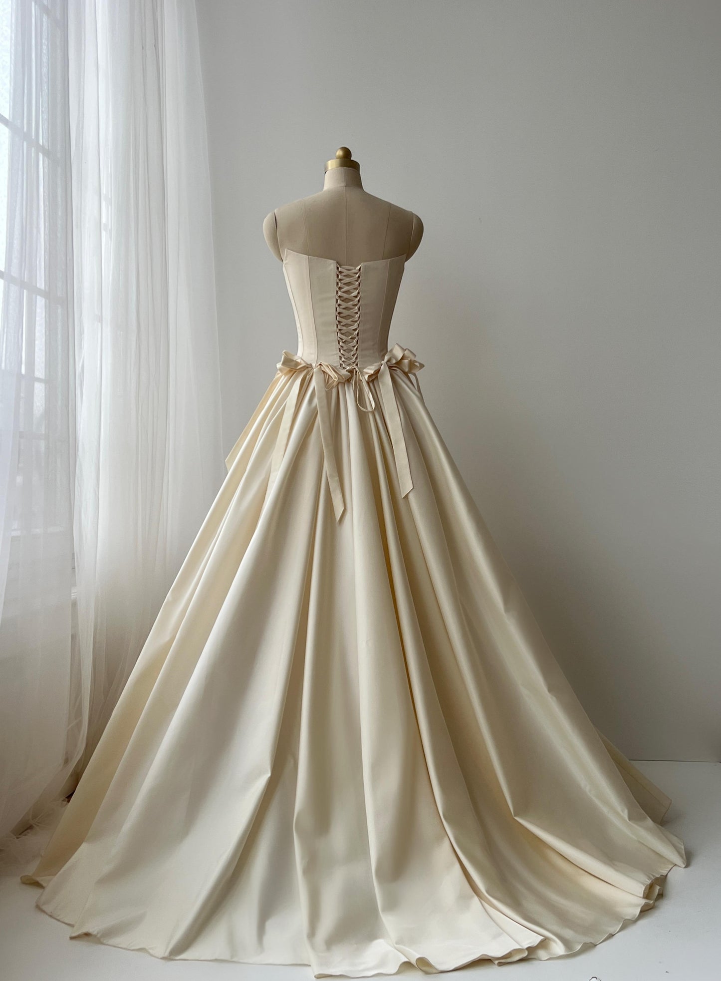 Beige A-Line bridal gown with no sleeves and embroidered bows
