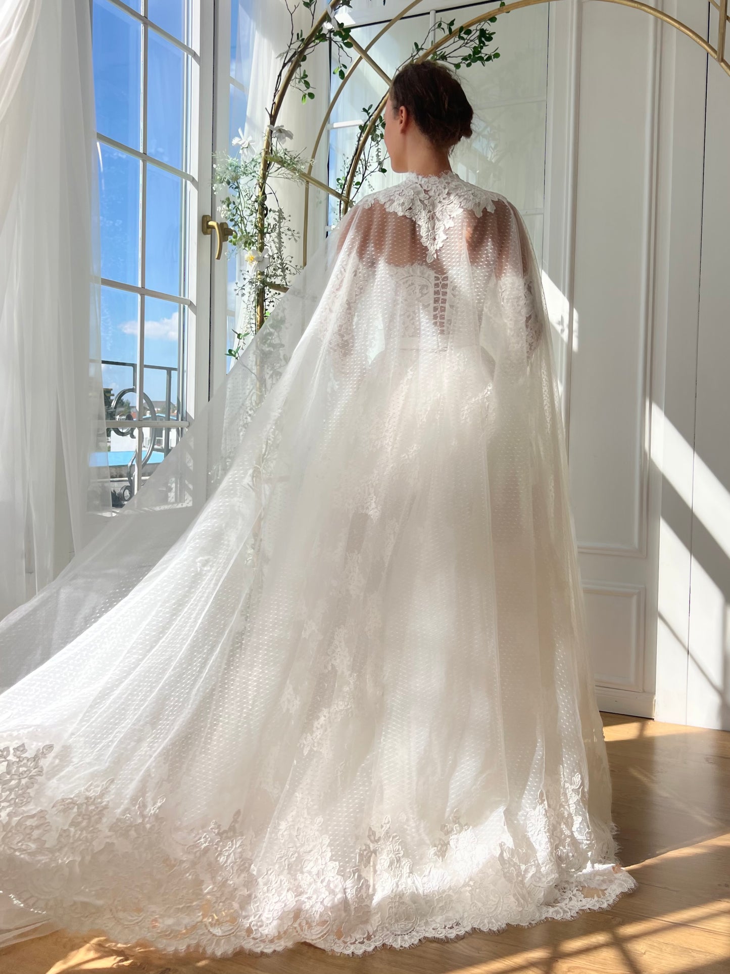 White bridal A-Line gown with long off the shoulders sleeves, cape and embroidery