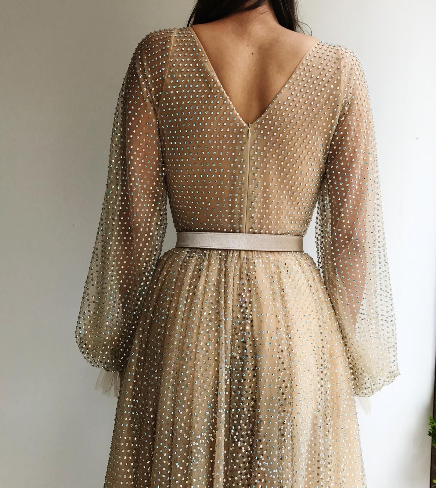 Beige sheath dress with v-neck, belt, long sleeves and beading
