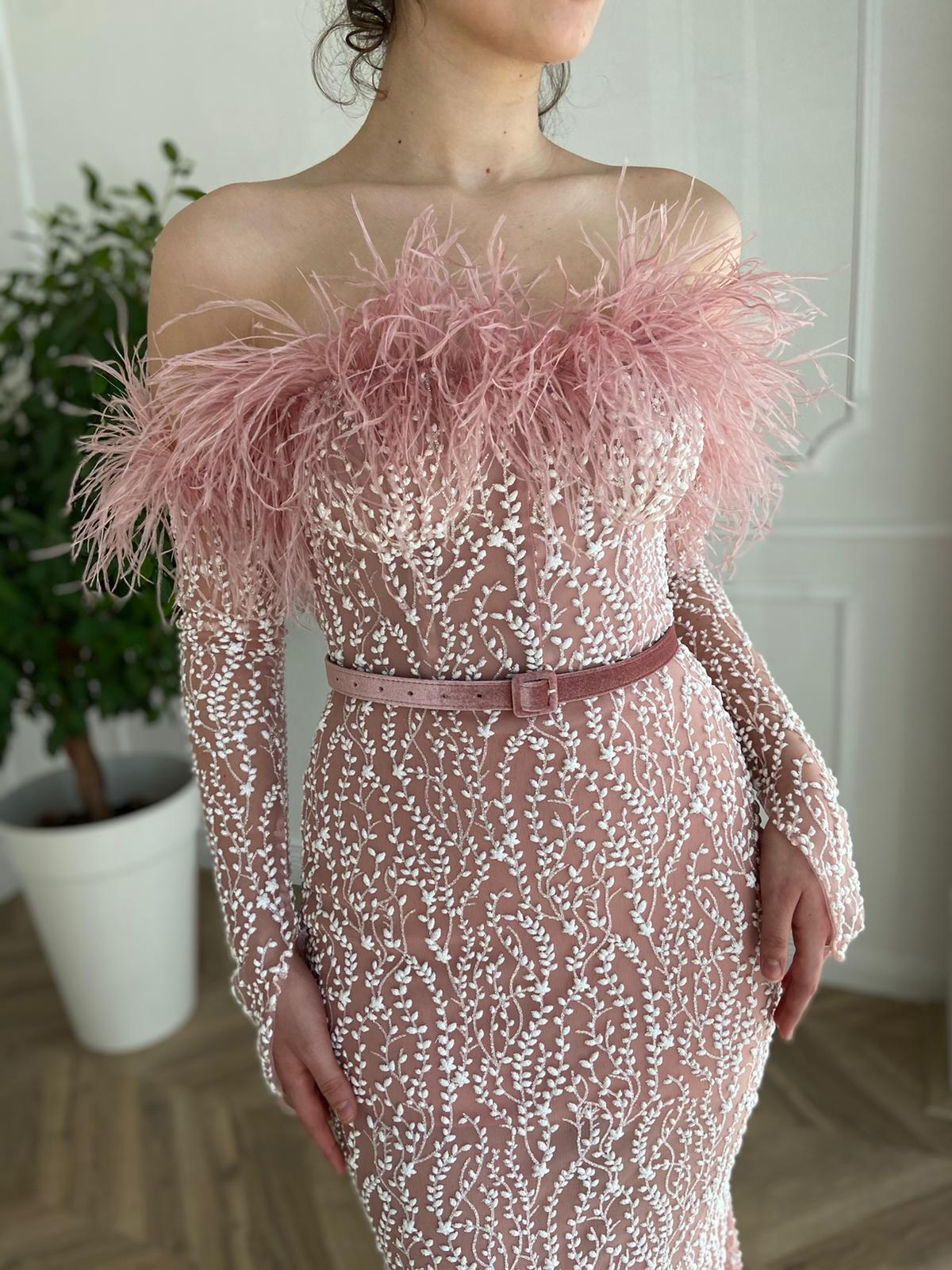 Pink mermaid dress with long off the shoulder sleeves, belt and feathers