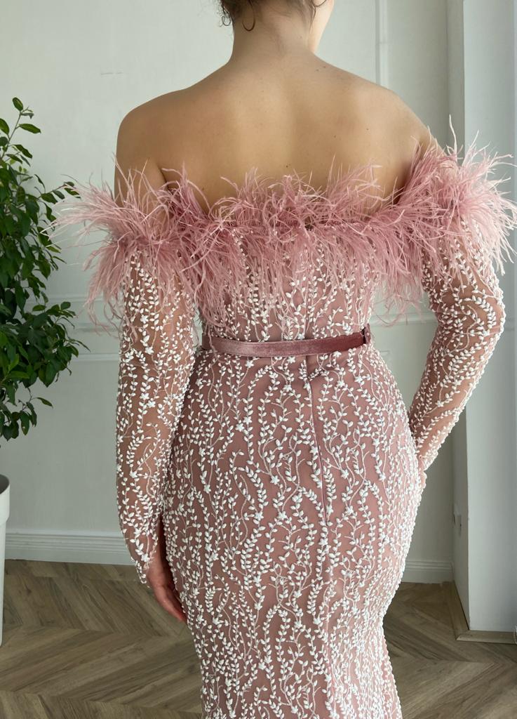Pink mermaid dress with long off the shoulder sleeves, belt and feathers