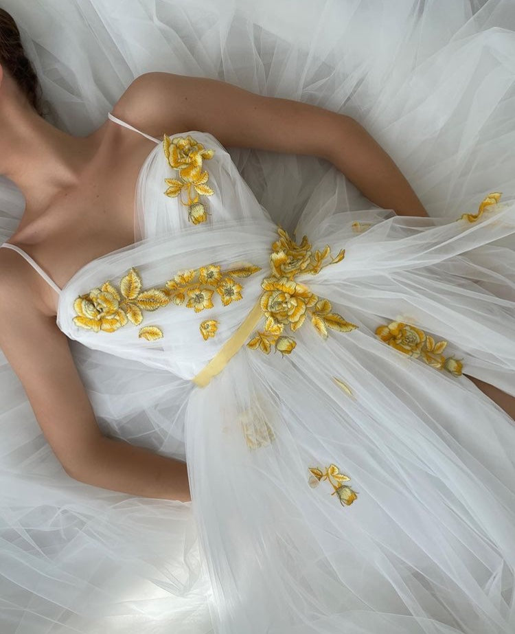 A line white bridal dress with spaghetti straps, embroidered flowers and slit