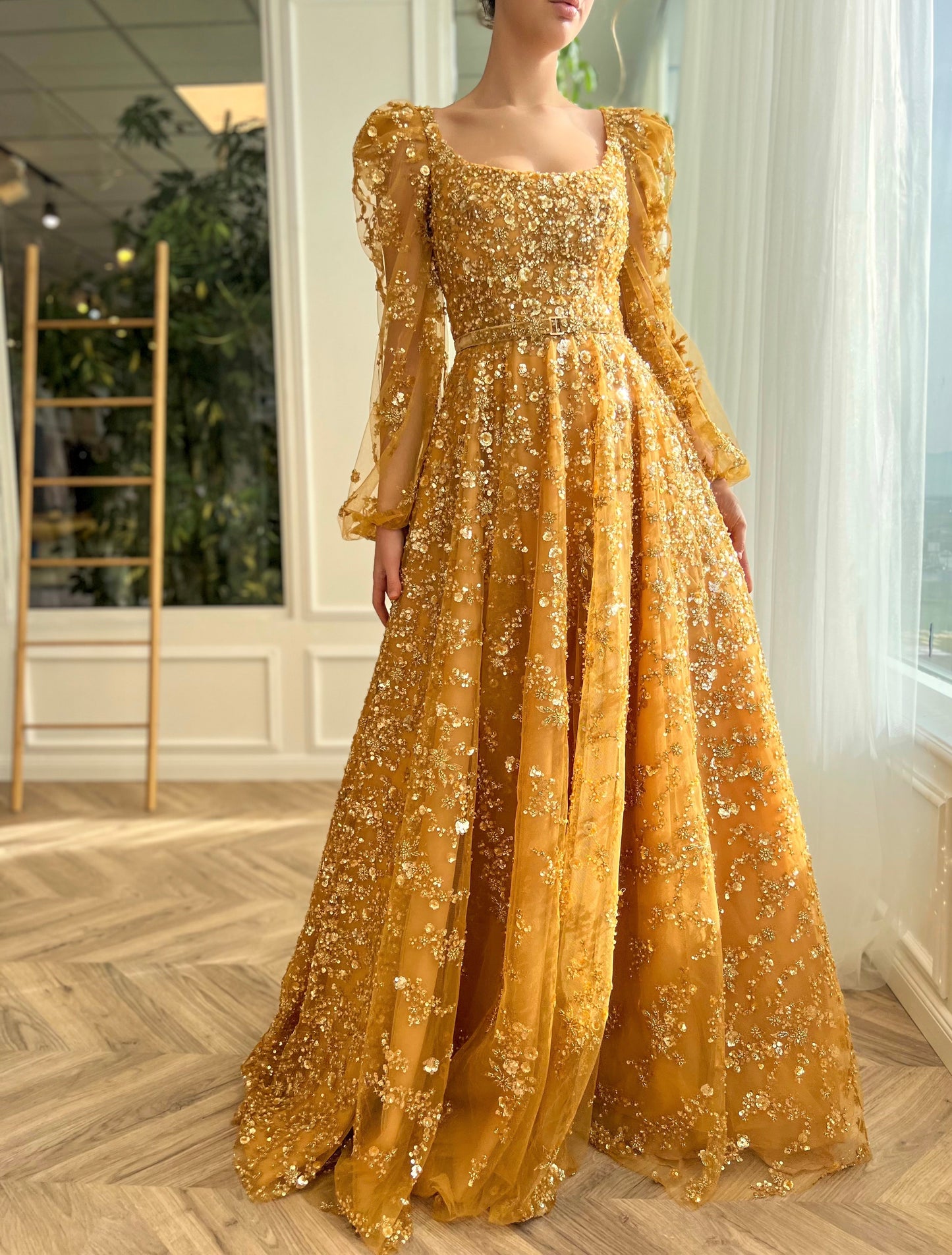 Gold A-line dress with long sleeves, belt and beading.