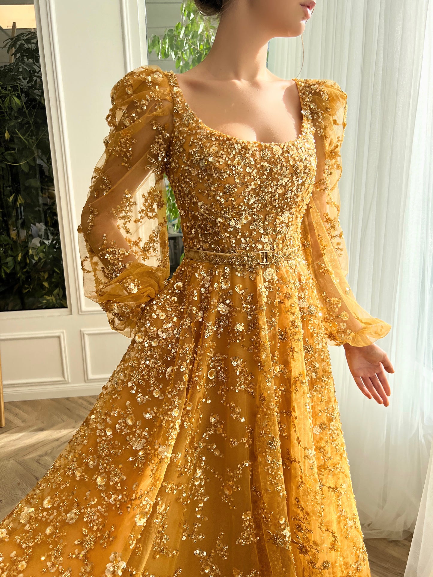 Gold A-line dress with long sleeves, belt and beading.