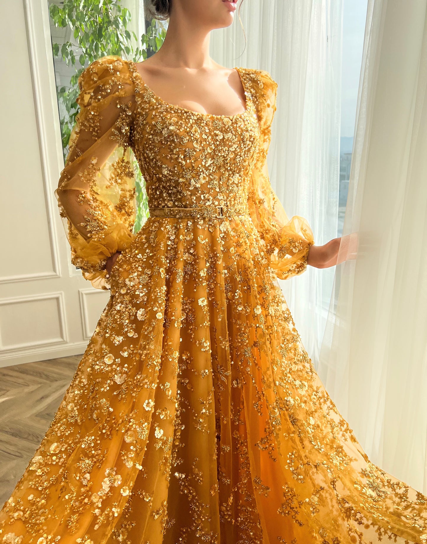 Gold A-line dress with long sleeves, belt and beading.