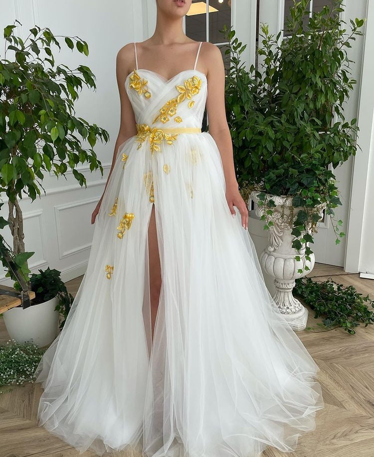 A line white bridal dress with spaghetti straps, embroidered flowers and slit