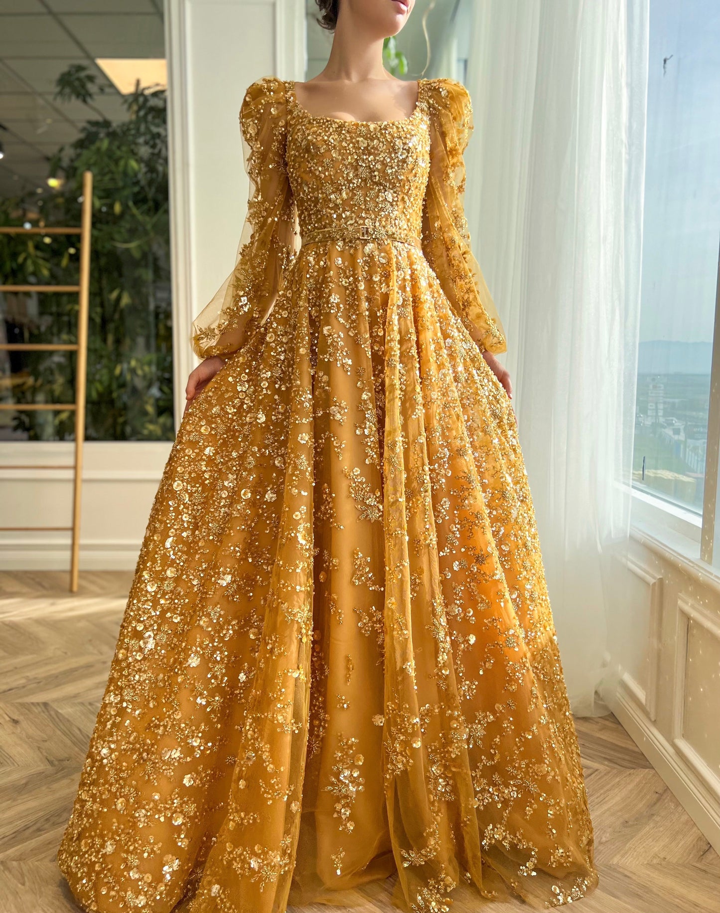 Gold A-line dress with long sleeves, belt and beading.