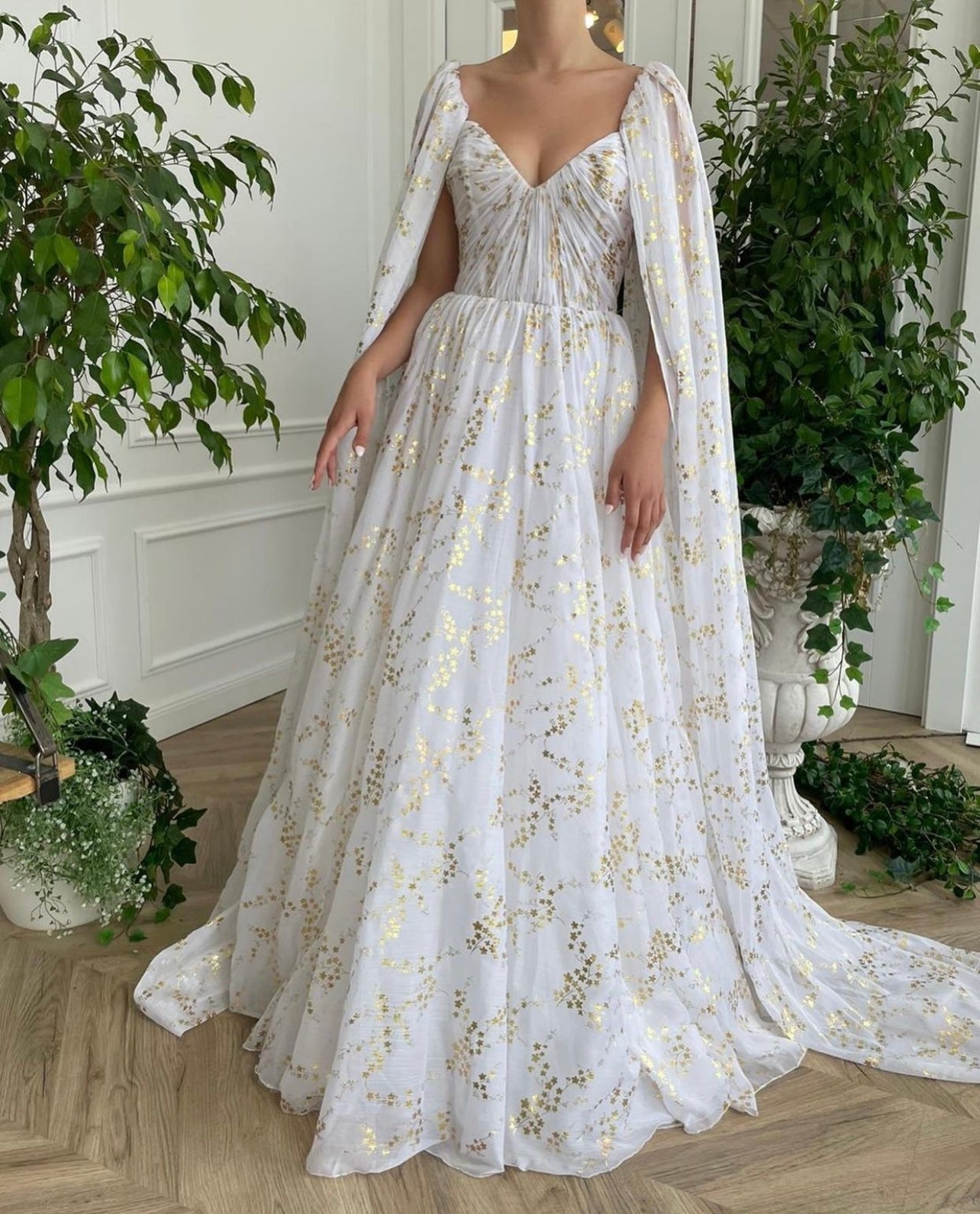 A line white bridal dress with cape, printed flowers and train