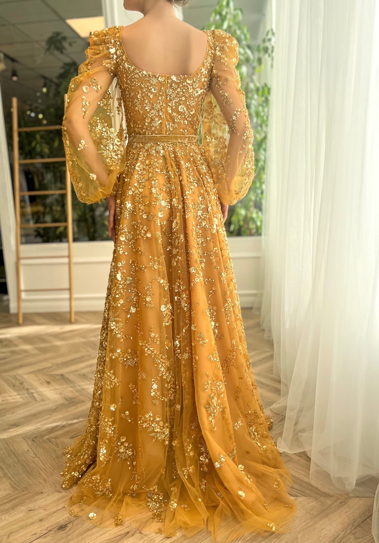 Gold A-line dress with long sleeves, belt and beading.