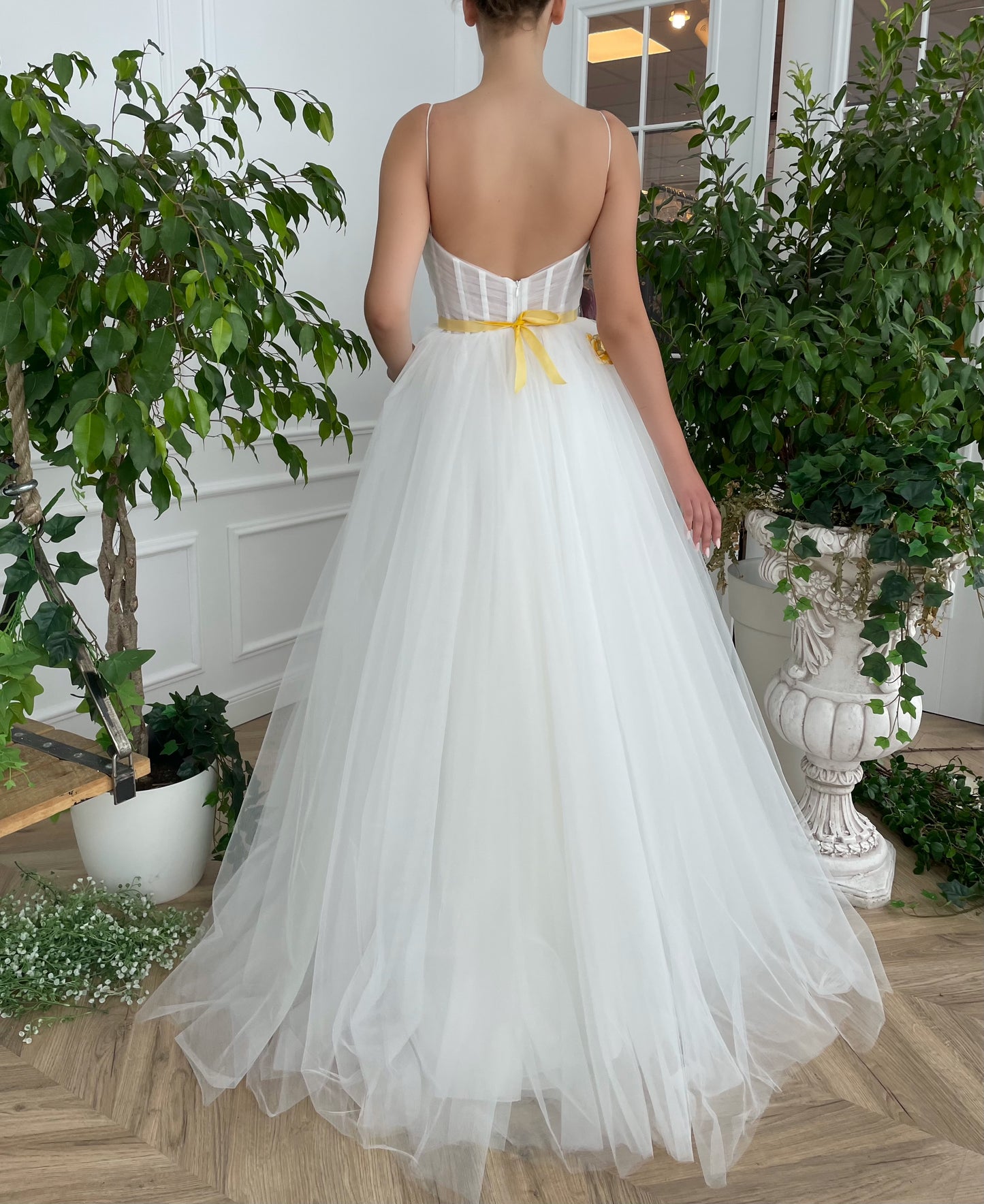 A line white bridal dress with spaghetti straps, embroidered flowers and slit