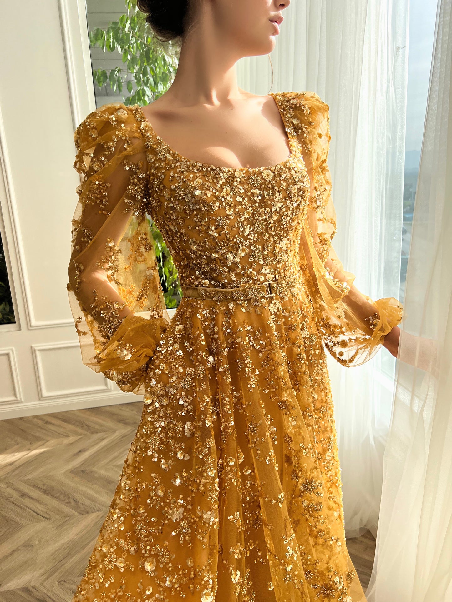 Gold A-line dress with long sleeves, belt and beading.