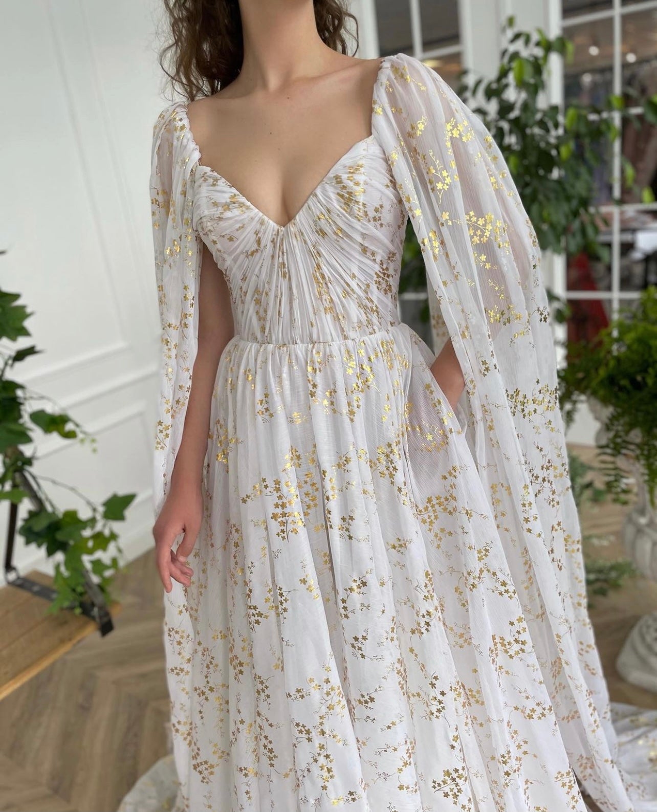 A line white bridal dress with cape, printed flowers and train