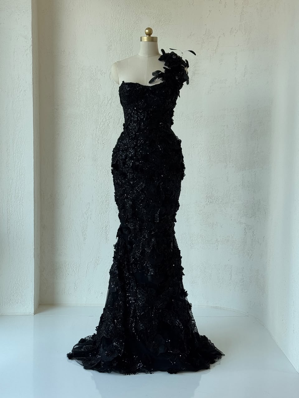 Black mermaid gown with one shoulder strap, embroidery and feathers