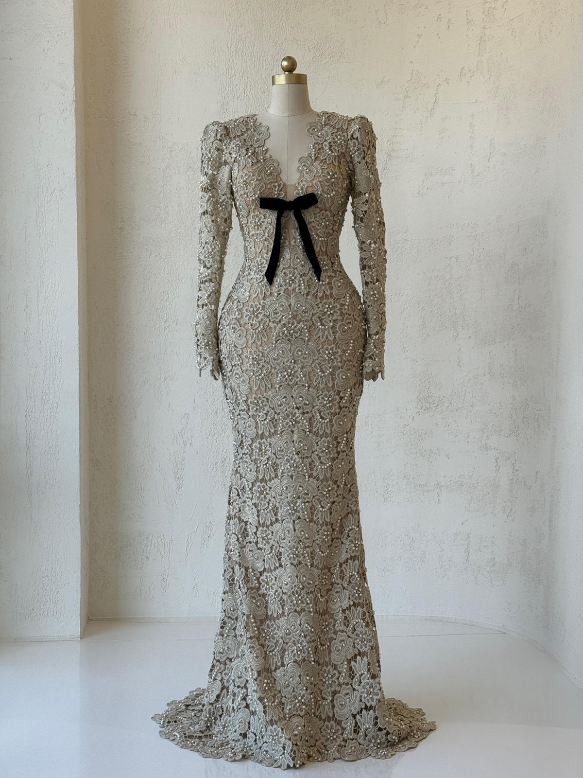 Beige mermaid gown with lace, embroidery, bow, v-neck and long sleeves