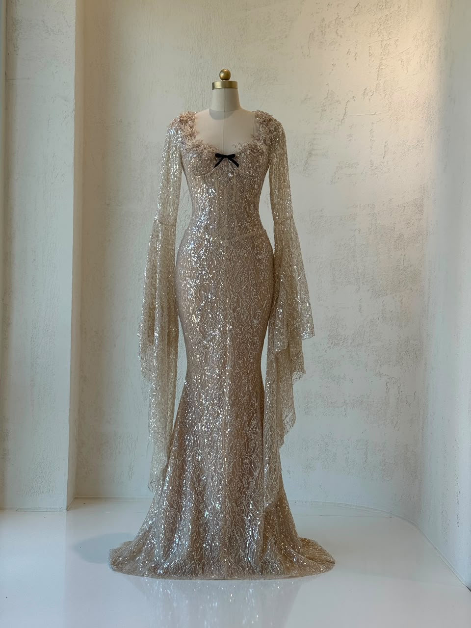 Beige mermaid gown with long flutter sleeves, embroidered bow, sequins and embroidery