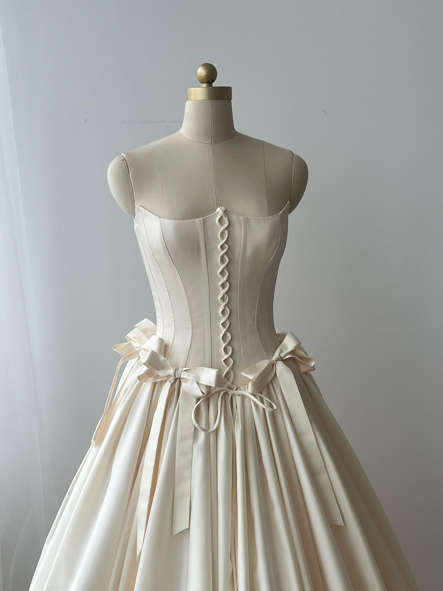 Beige A-Line bridal gown with no sleeves and embroidered bows