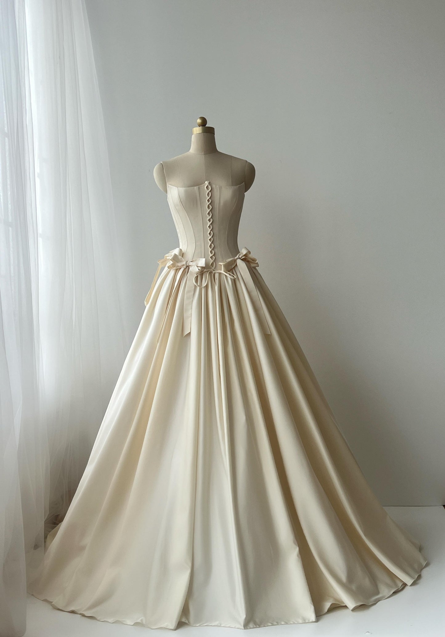 Beige A-Line bridal gown with no sleeves and embroidered bows