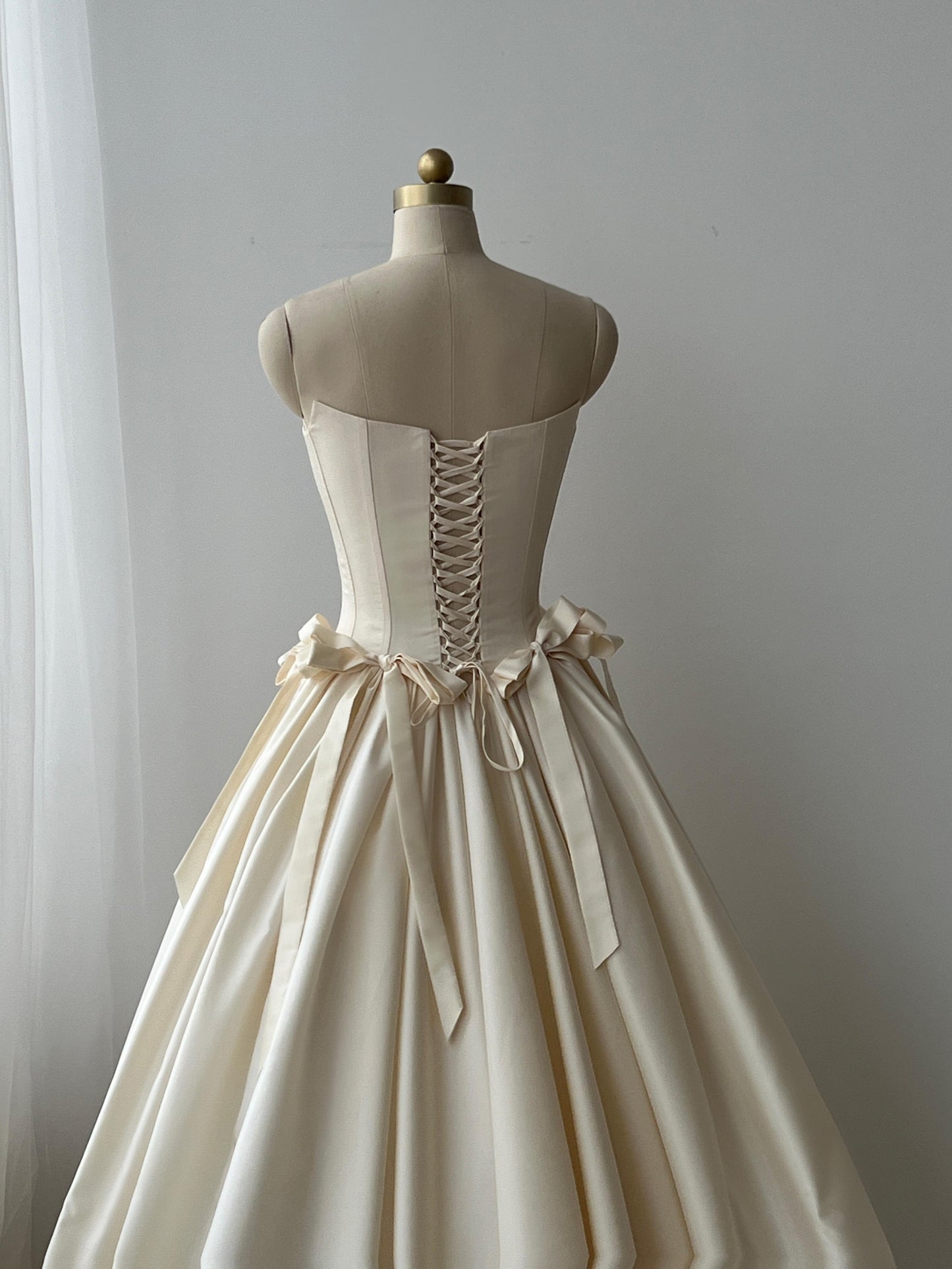 Beige A-Line bridal gown with no sleeves and embroidered bows