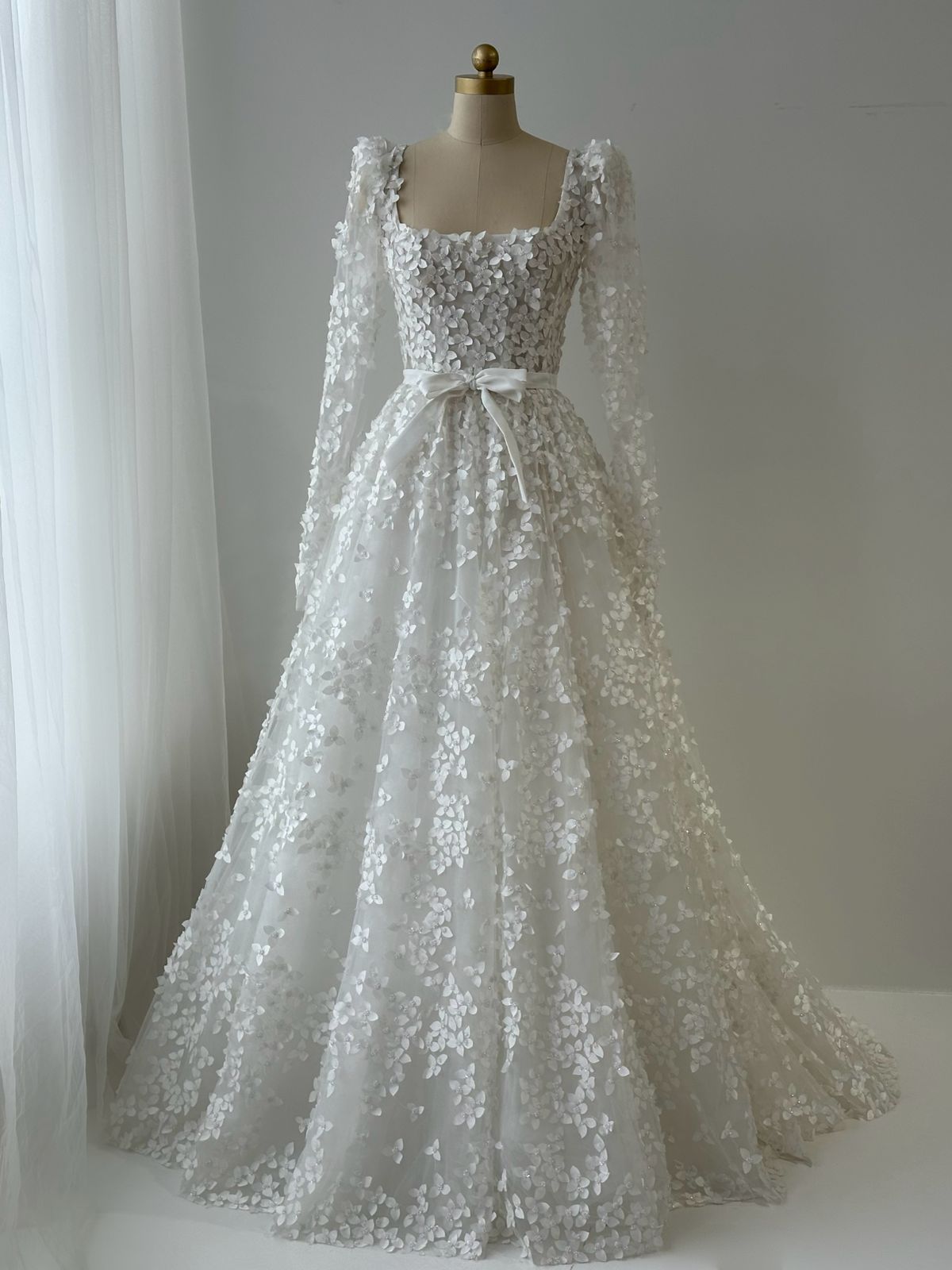 White bridal A-Line gown with long sleeves, bow and embroidery