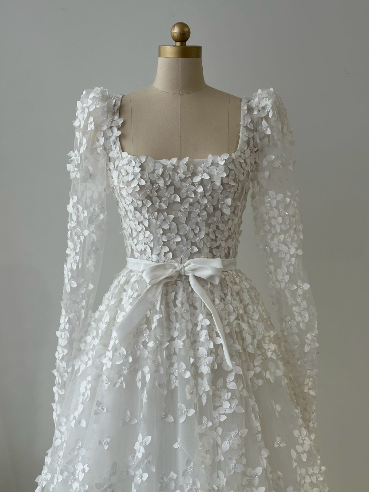 White bridal A-Line gown with long sleeves, bow and embroidery