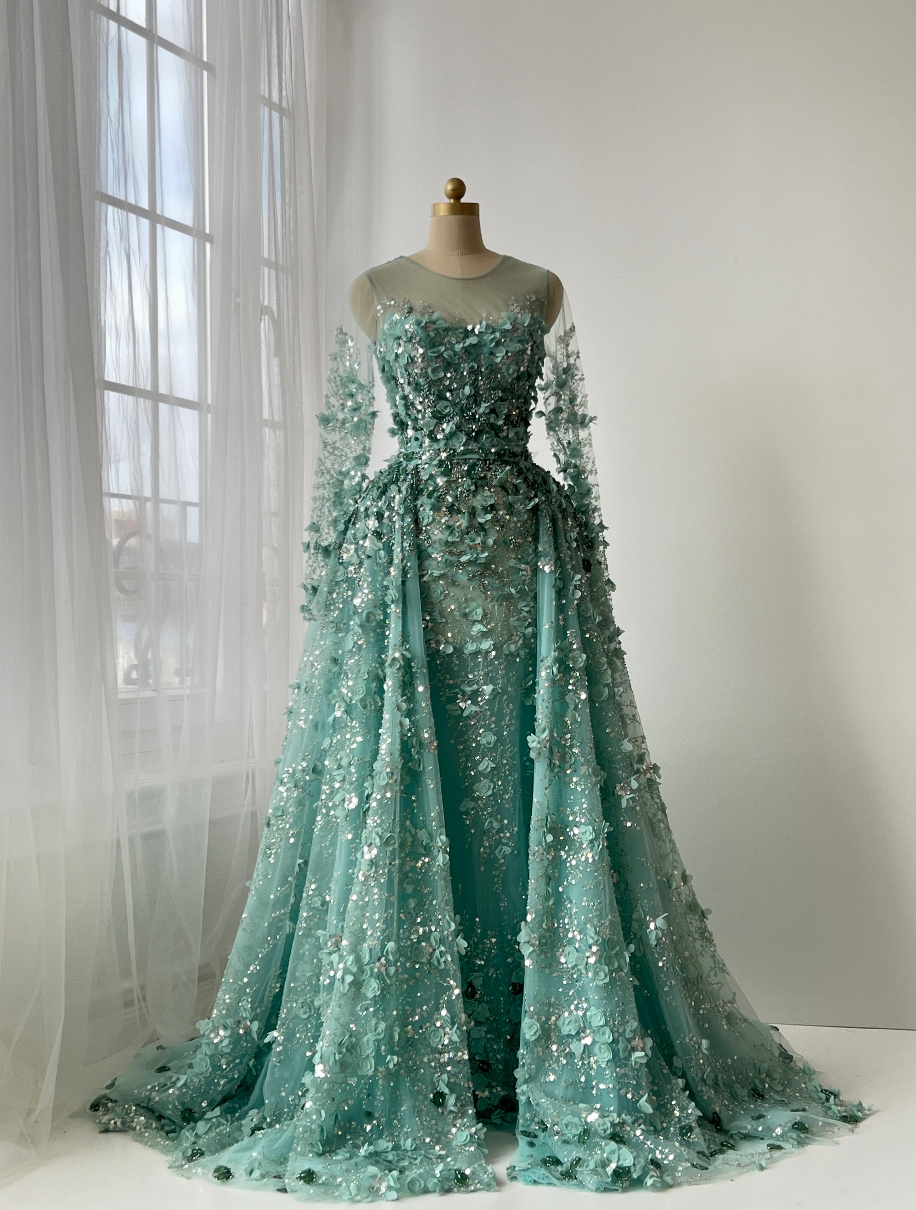 Turquoise A-Line gown with floral and sequin details, long sleeves and overskirt