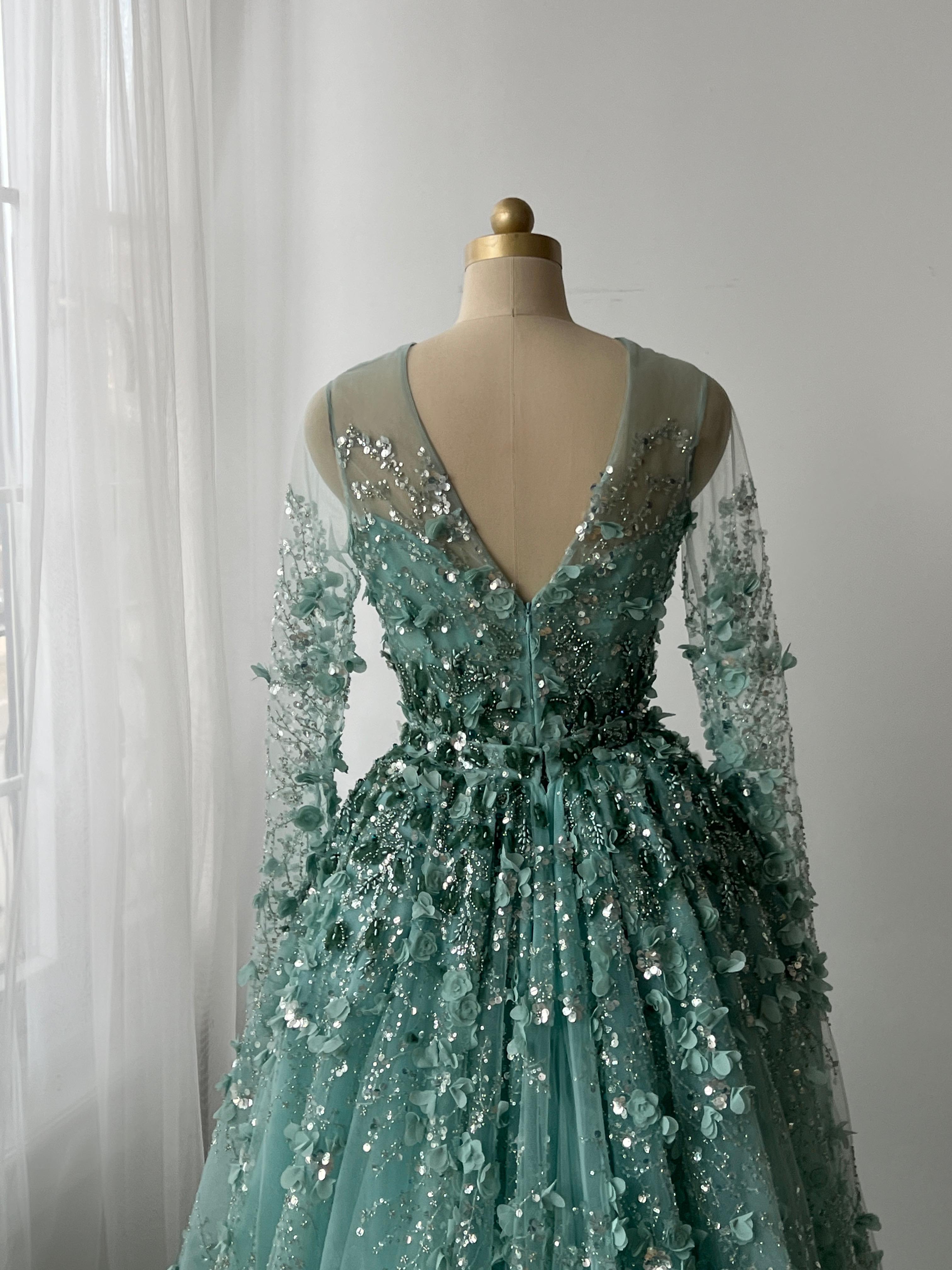 Turquoise A-Line gown with floral and sequin details, long sleeves and overskirt