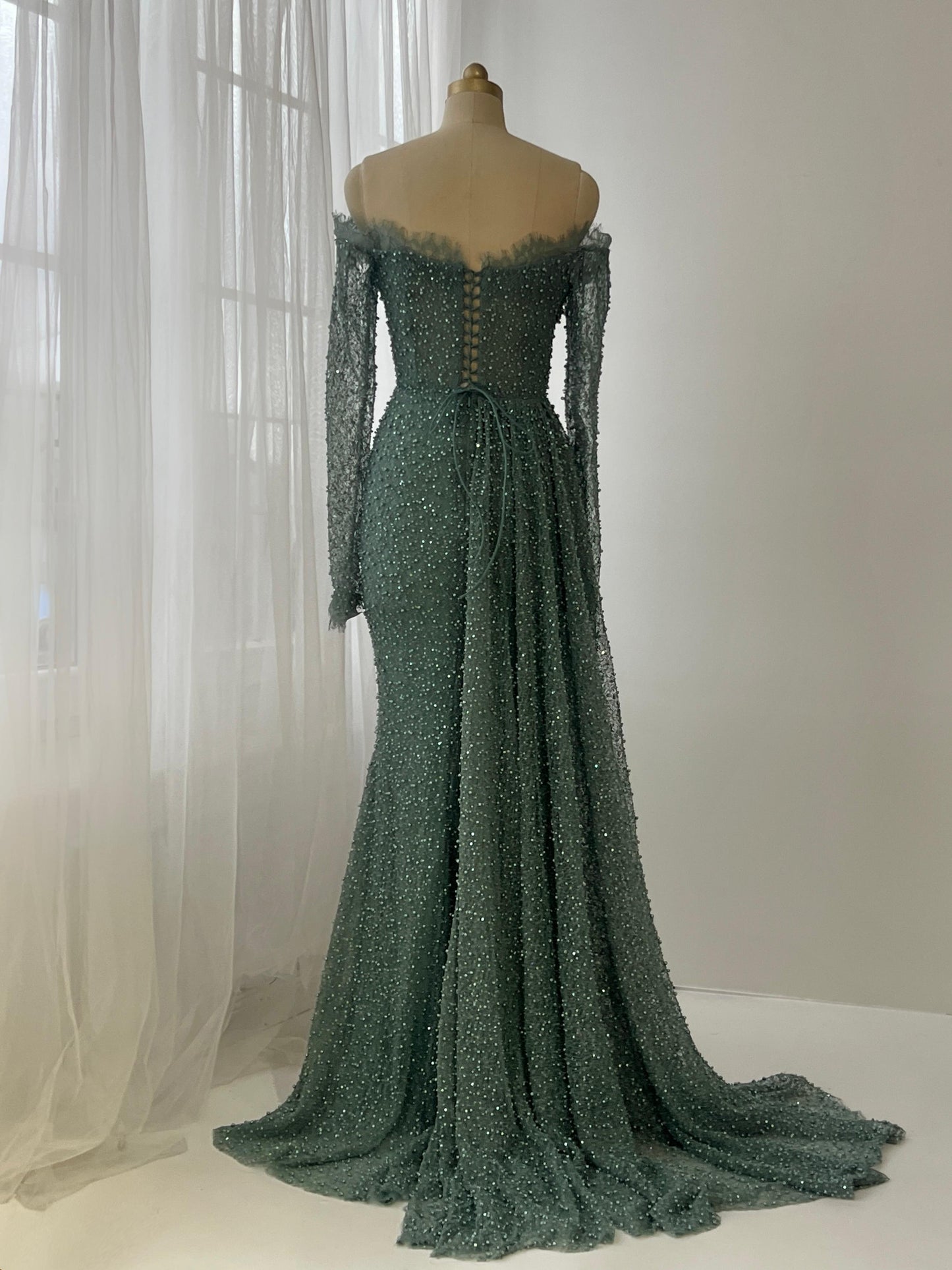 Turquoise mermaid gown with long off the shoulder sleeves, lace and beading work
