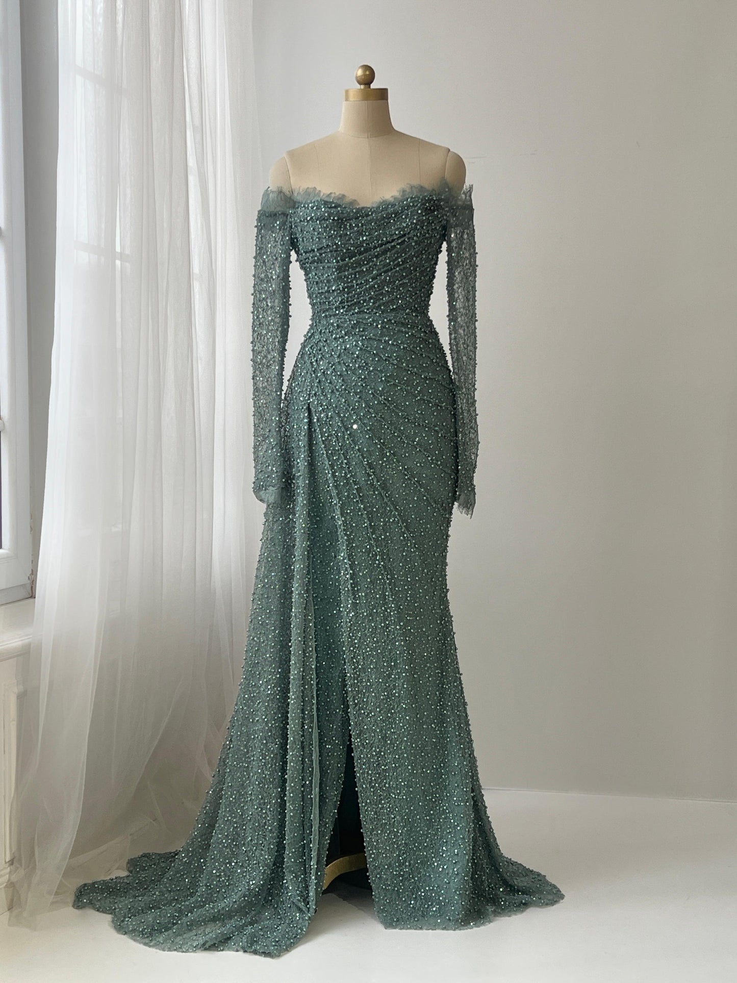 Turquoise mermaid gown with long off the shoulder sleeves, lace and beading work