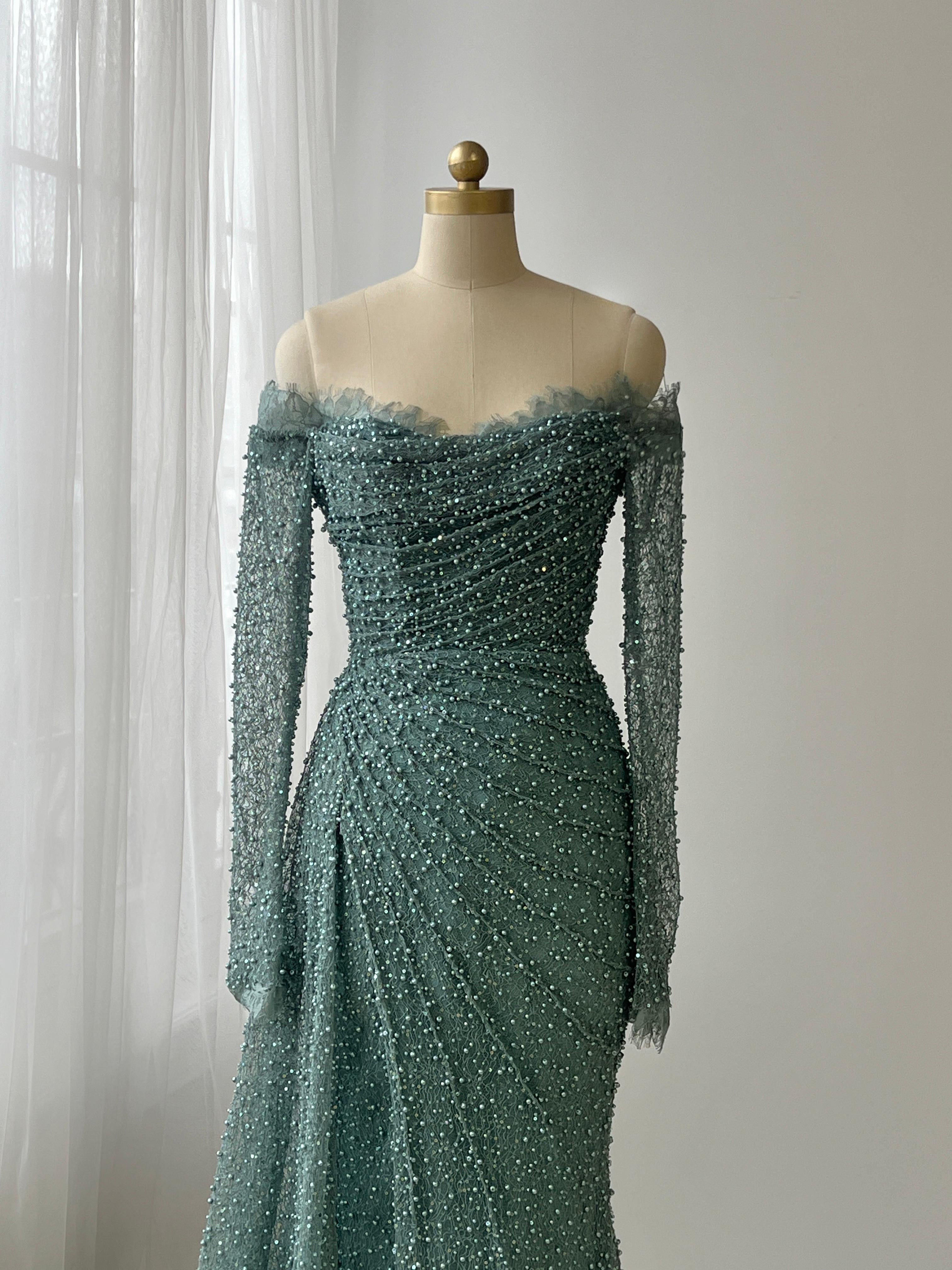 Turquoise mermaid gown with long off the shoulder sleeves, lace and beading work