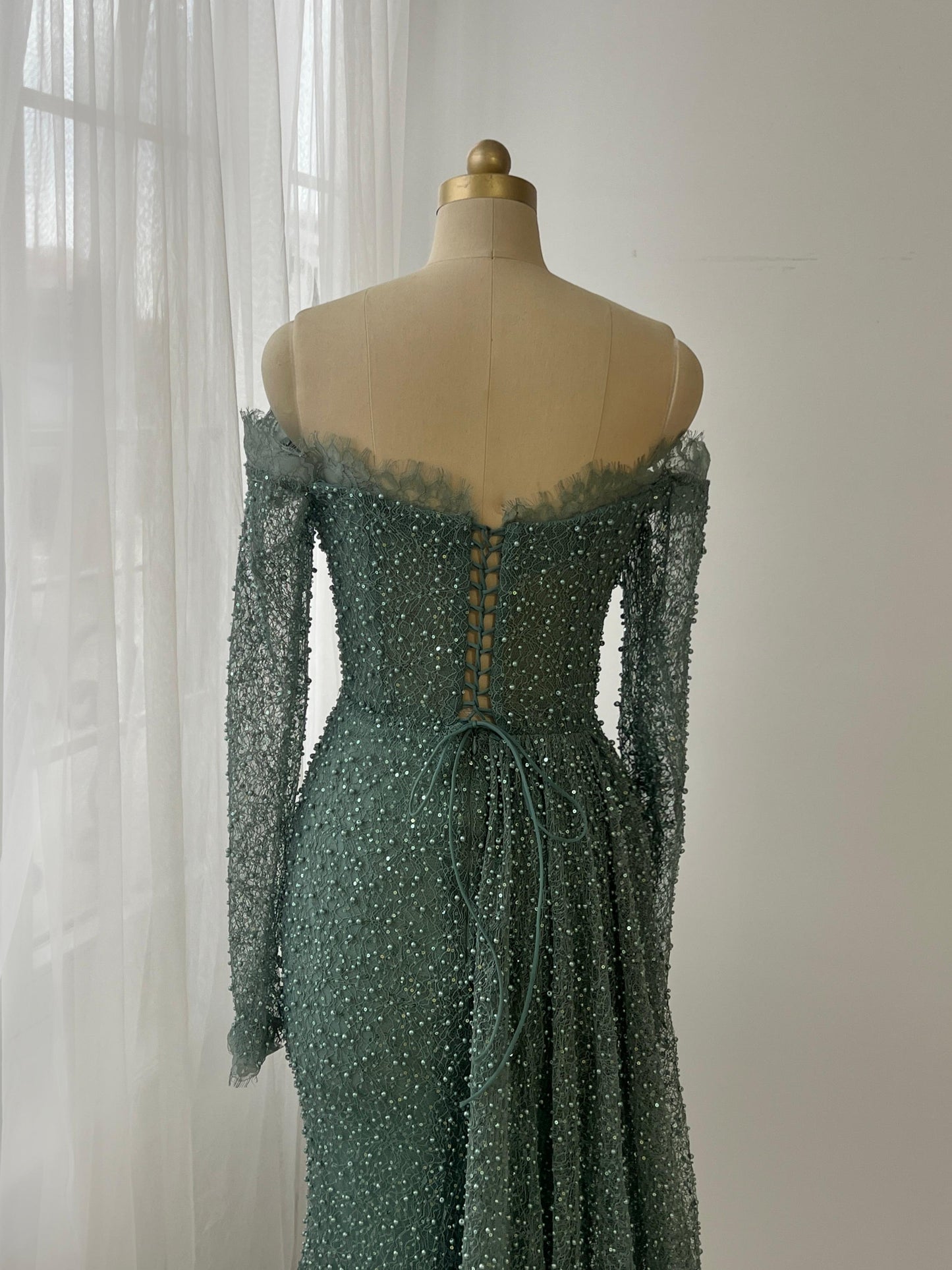 Turquoise mermaid gown with long off the shoulder sleeves, lace and beading work