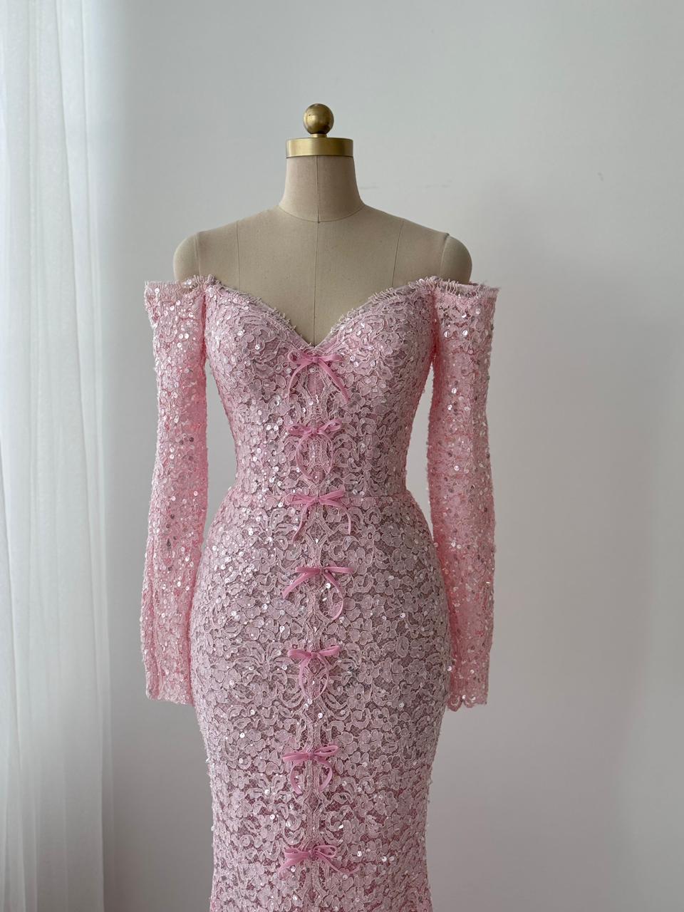 Pink mermaid gown with long off the shoulder sleeves, embroidered bows and lace