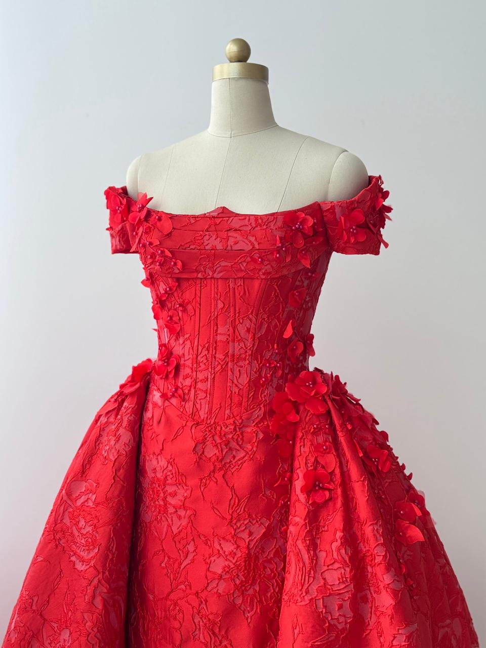 Red A-line gown with overskirt, off the shoulder sleeves and embroidery