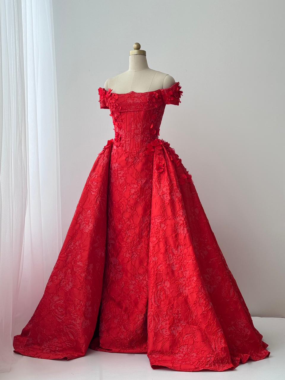 Red A-line gown with overskirt, off the shoulder sleeves and embroidery