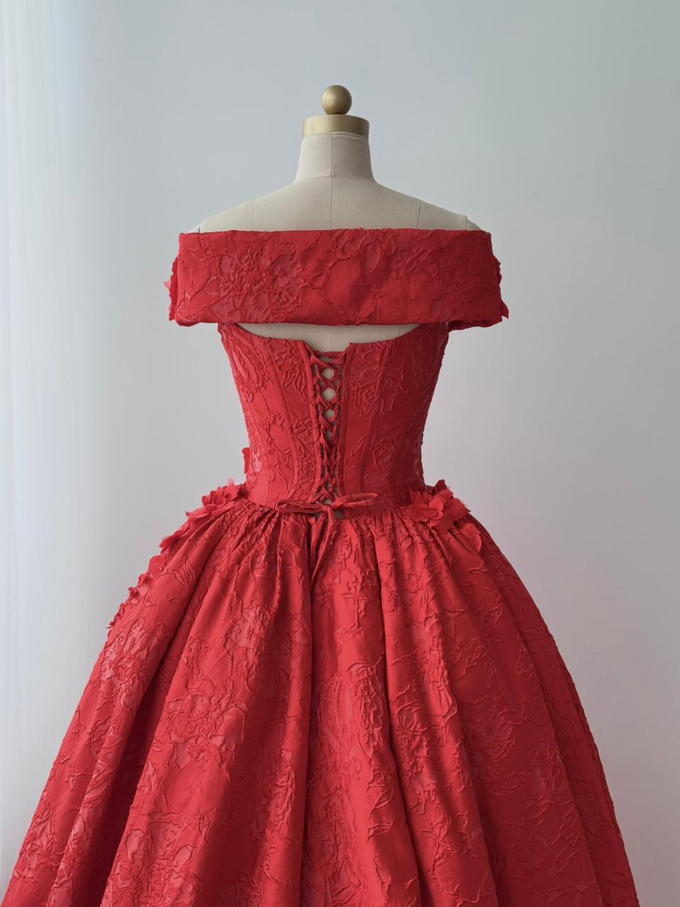 Red A-line gown with overskirt, off the shoulder sleeves and embroidery