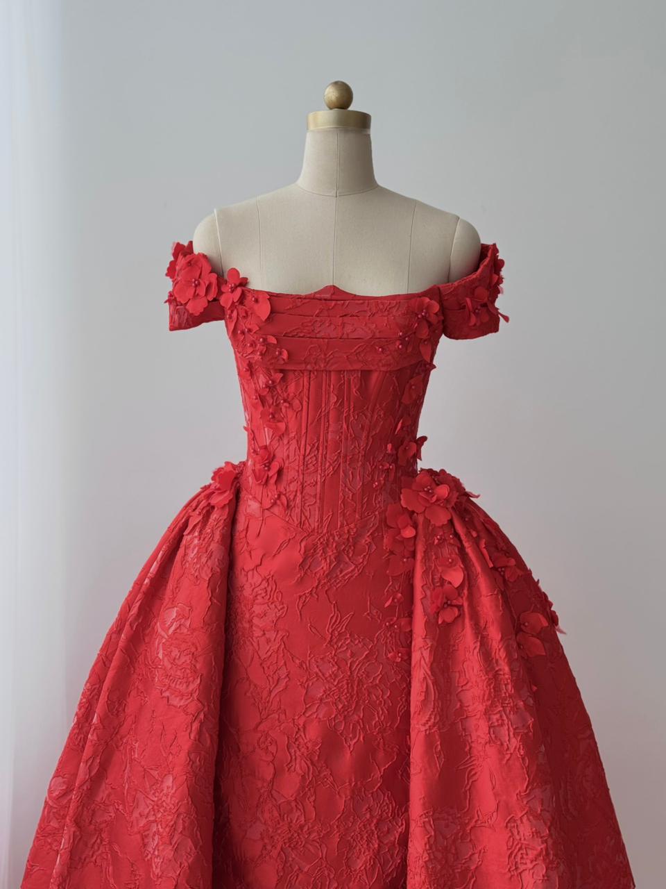 Red A-line gown with overskirt, off the shoulder sleeves and embroidery