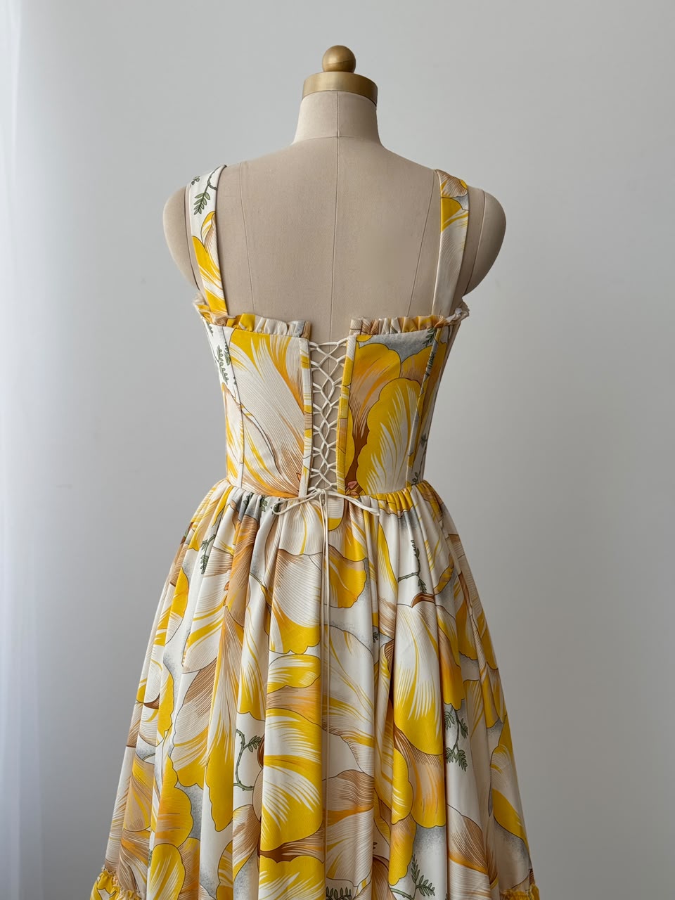 Yellow midi dress with printed floral fabric, straps and embroidered work