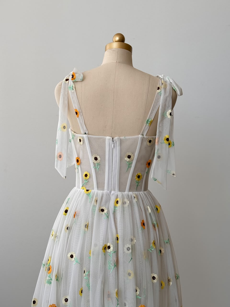 White midi dress with bow straps and embroidered colorful flowers