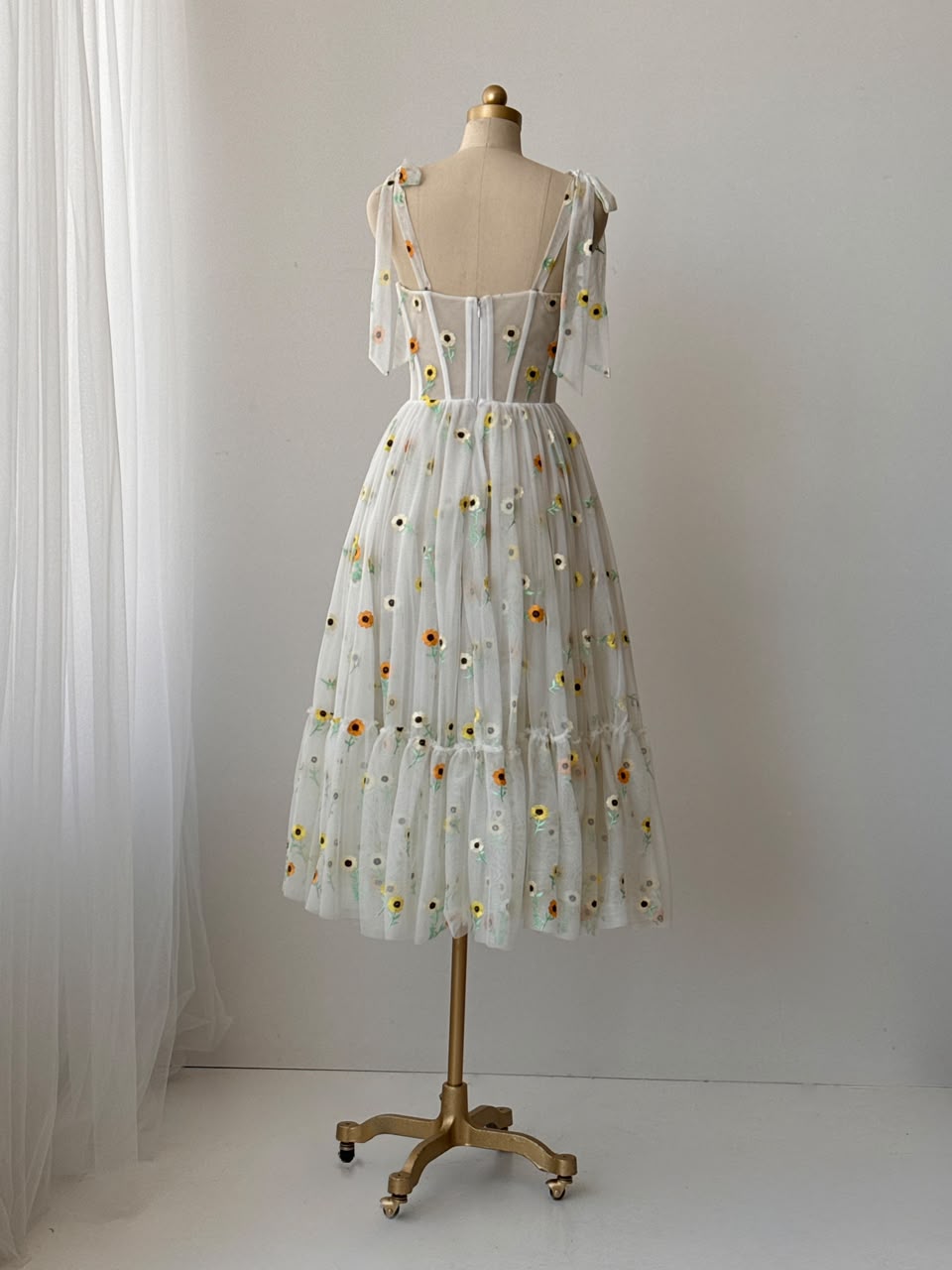 White midi dress with bow straps and embroidered colorful flowers