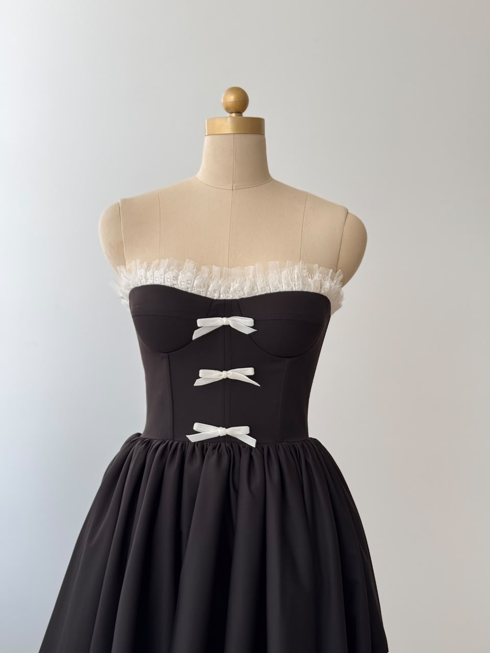 Black midi dress with ruffles, embroidered bows and no sleeves