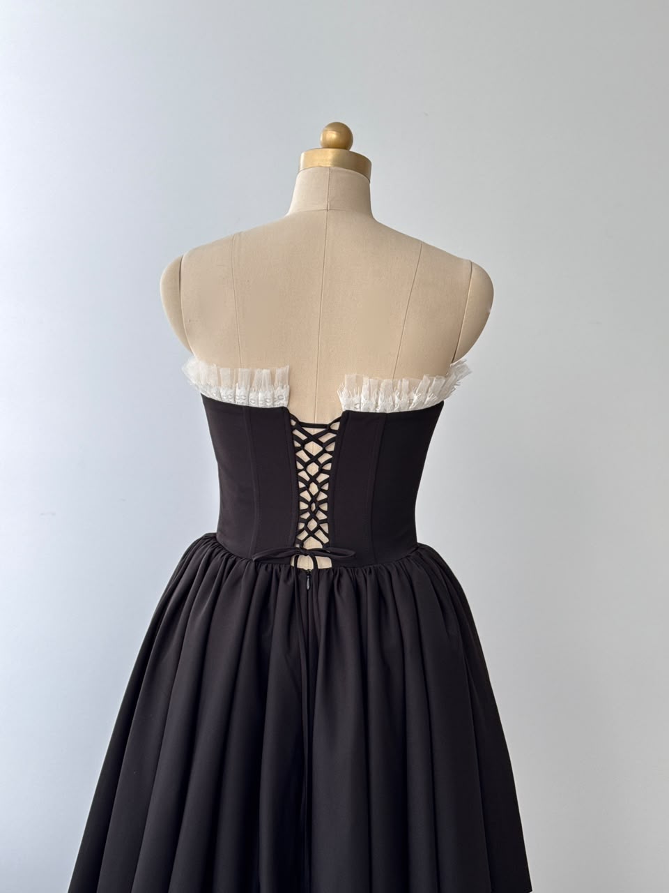 Black midi dress with ruffles, embroidered bows and no sleeves