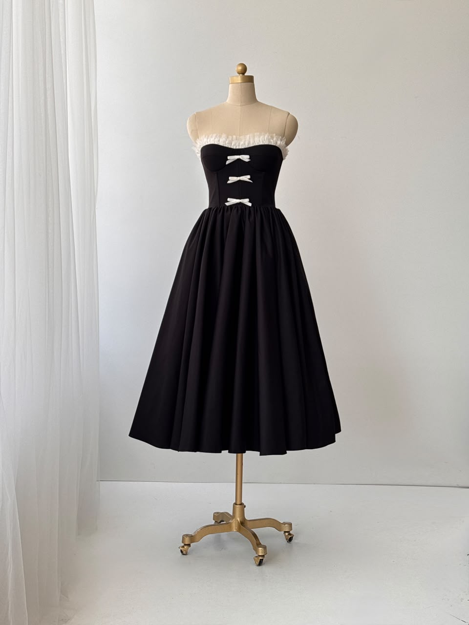 Black midi dress with ruffles, embroidered bows and no sleeves