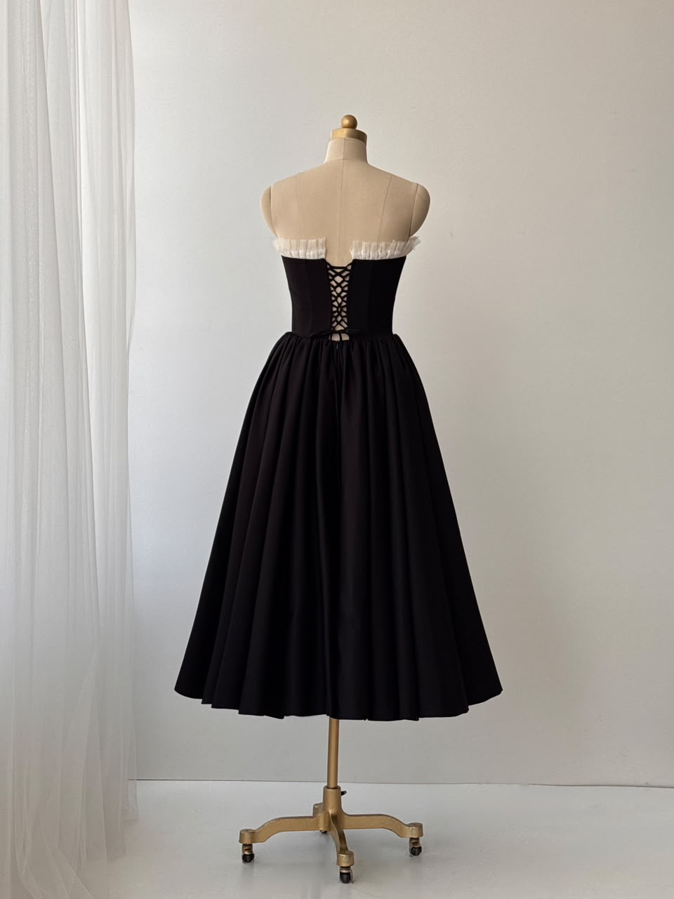 Black midi dress with ruffles, embroidered bows and no sleeves