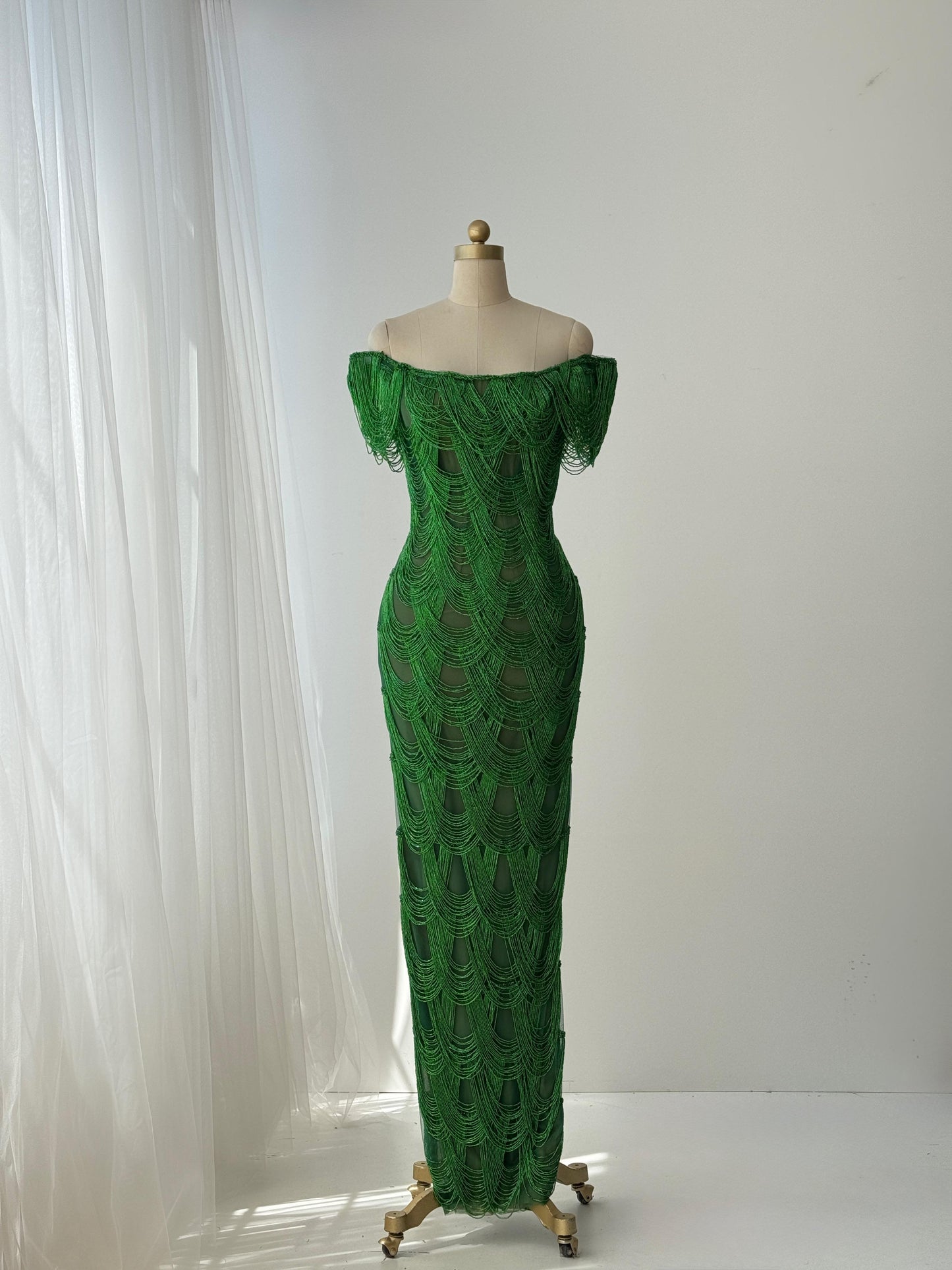 Dark green mermaid gown with off the shoulder straps and fringes