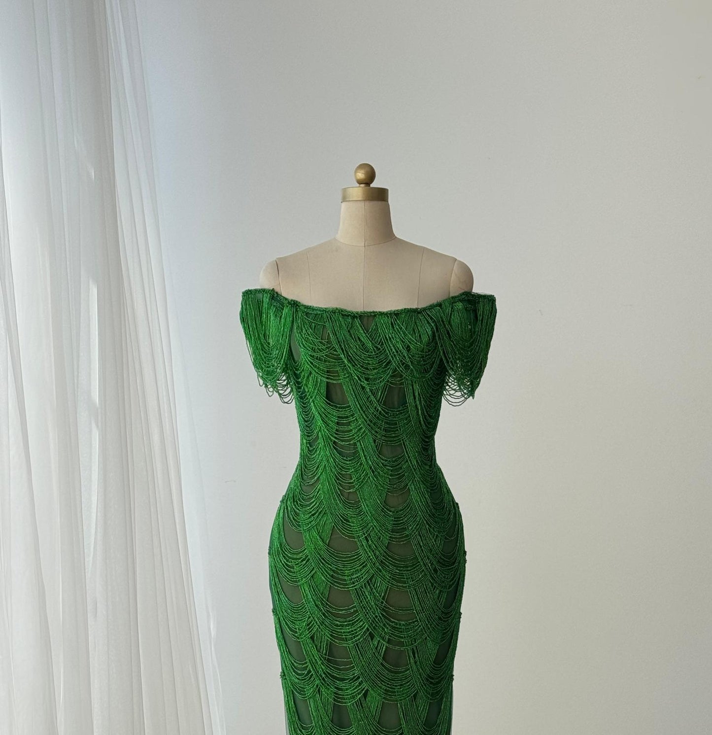Dark green mermaid gown with off the shoulder straps and fringes