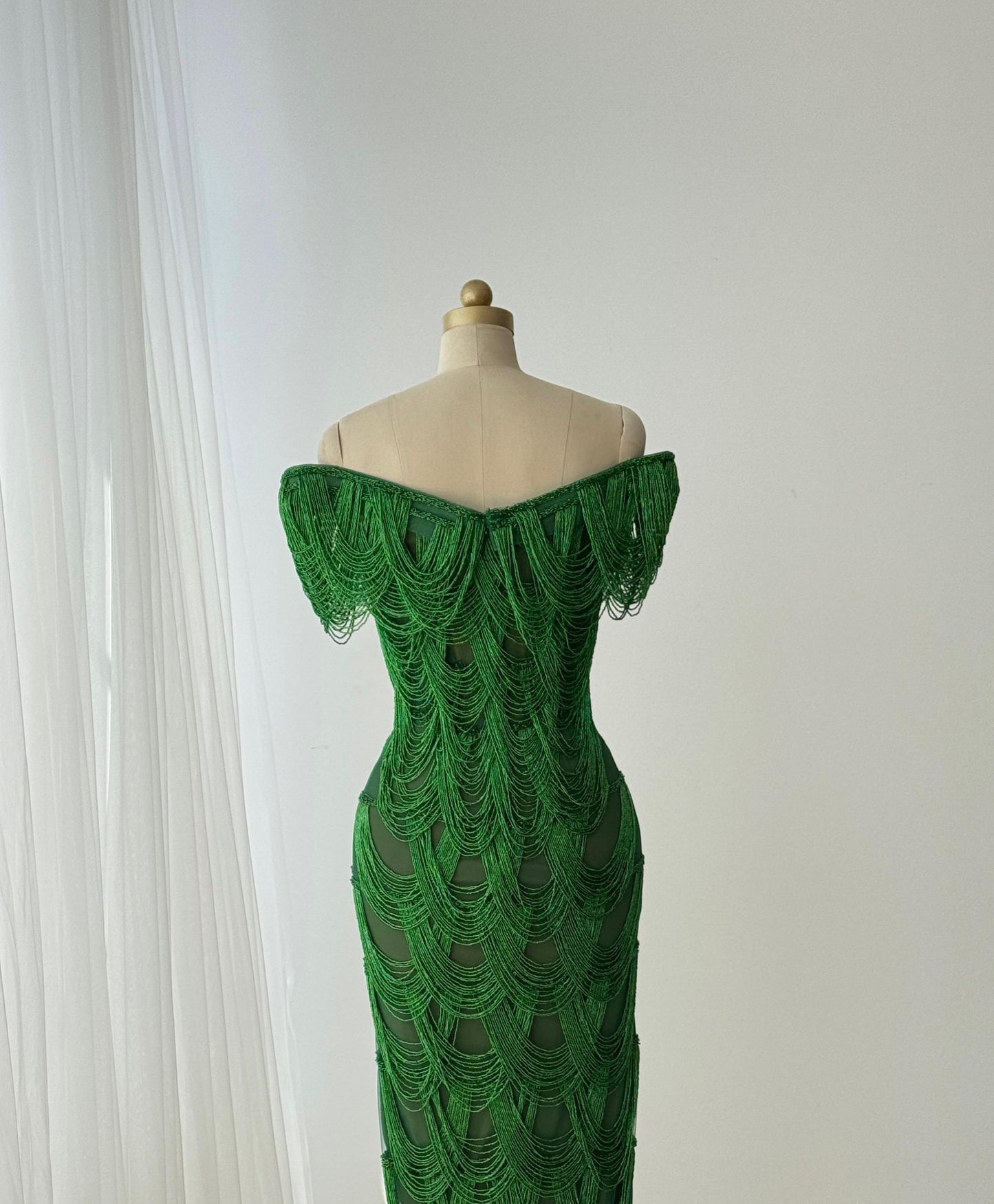 Dark green mermaid gown with off the shoulder straps and fringes