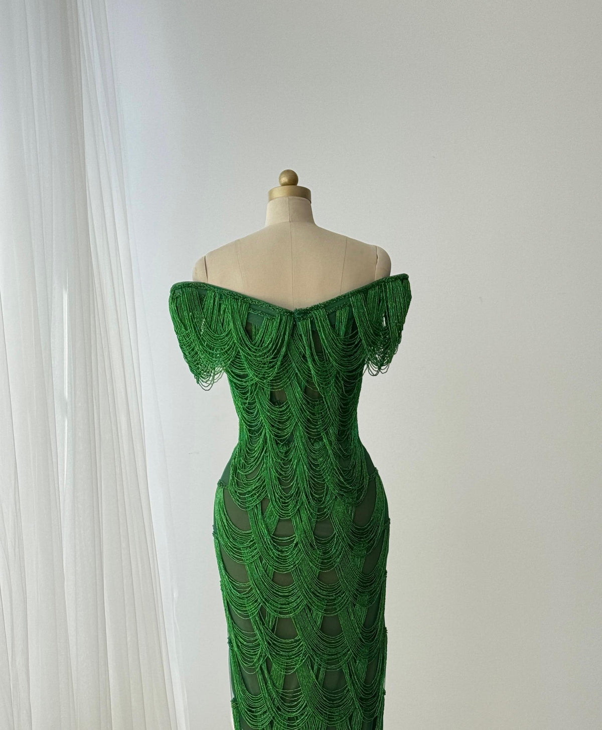 Dark green mermaid gown with off the shoulder straps and fringes