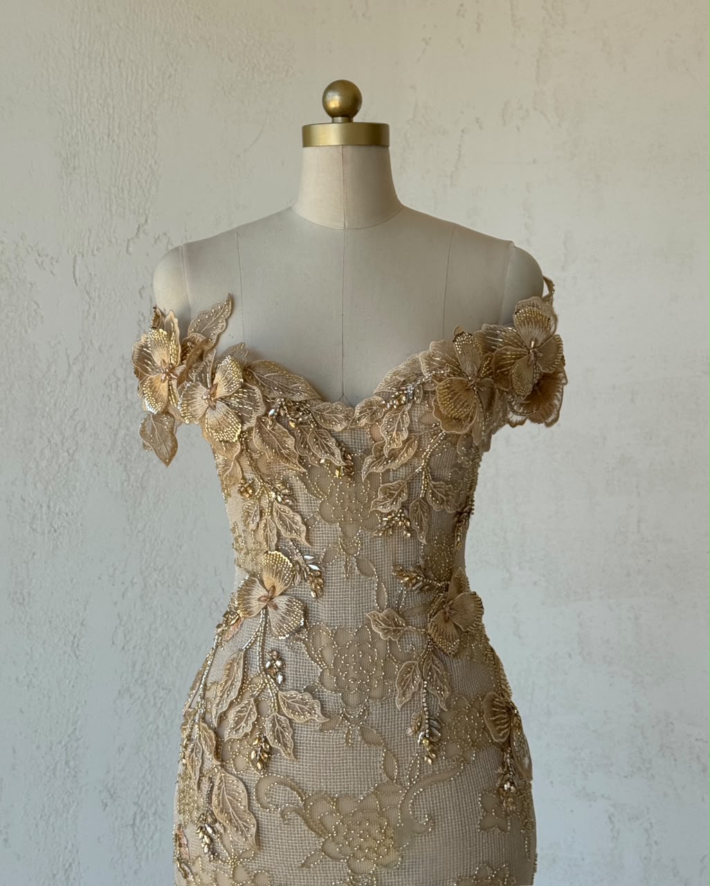 Beige mermaid gown with off the shoulder sleeves and embroidery