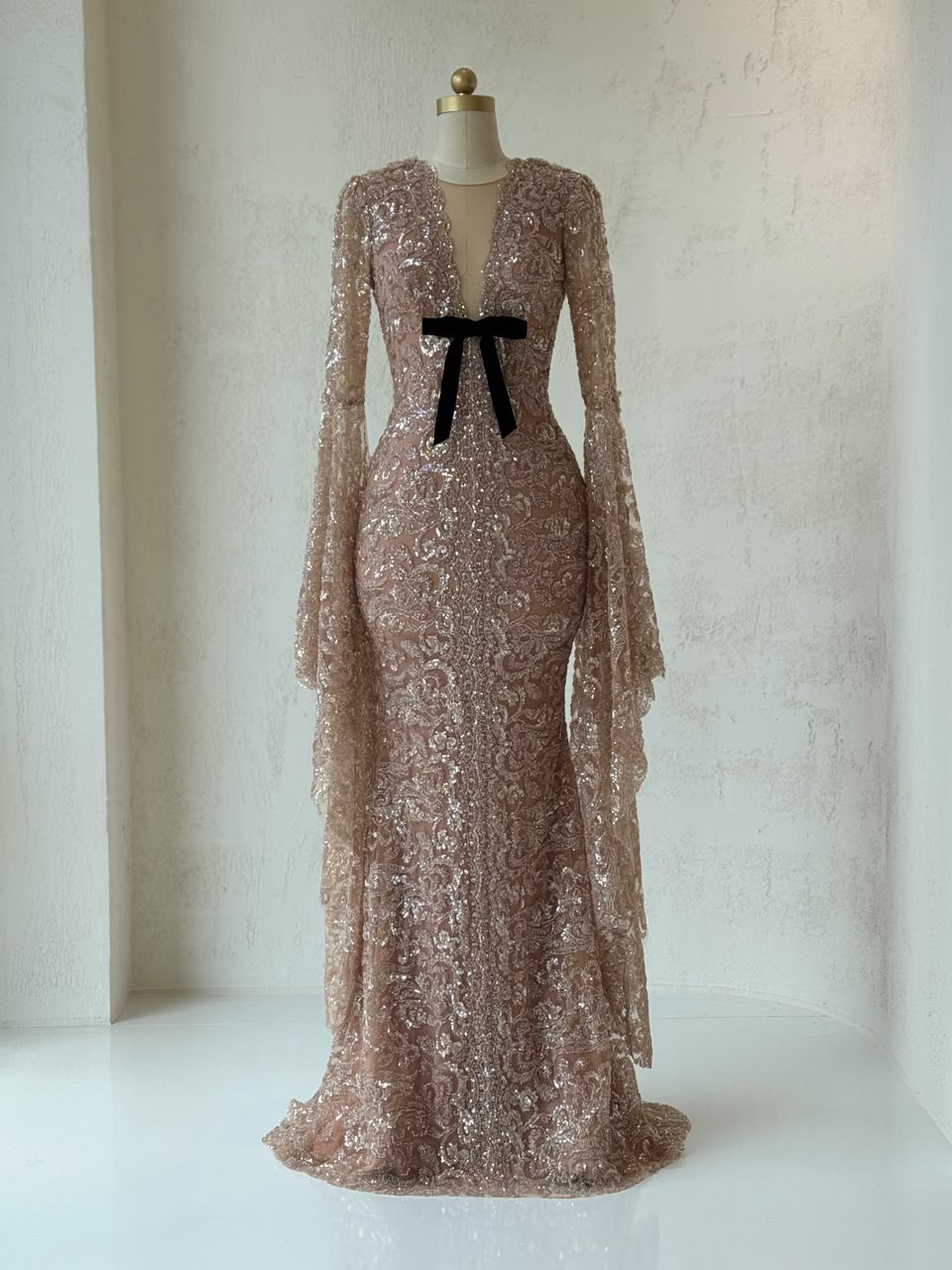 Rose gold mermaid gown with v-neck, embroidered bow, long flutter sleeves and sequins