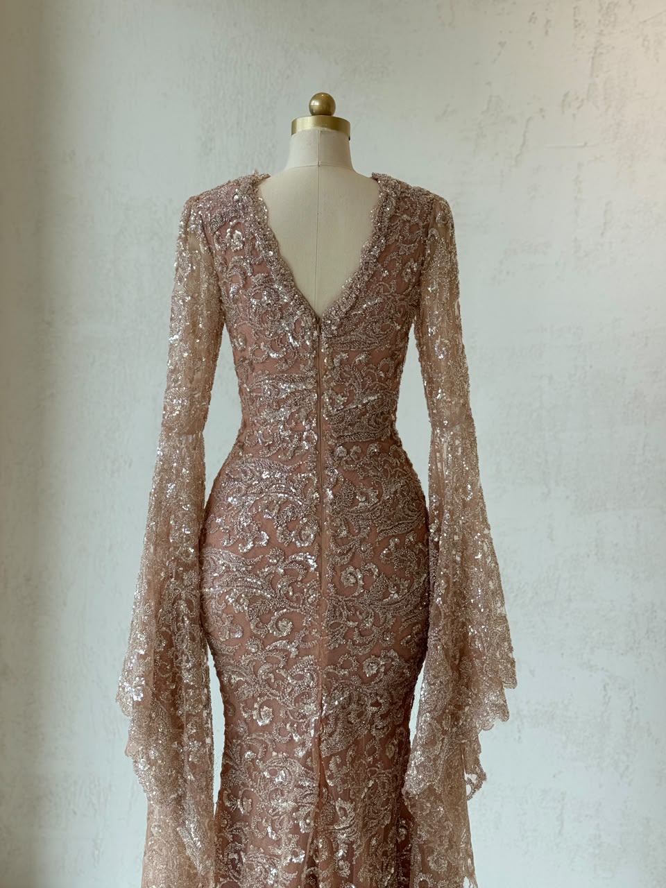 Rose gold mermaid gown with v-neck, embroidered bow, long flutter sleeves and sequins